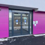 Commercial black doors installed by First Windows with pink walls